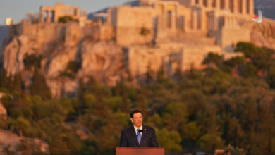 Marco Rubio speaking at a podium in Athens with the Acropolis in the background