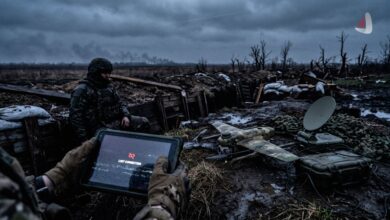 Soldier in a muddy trench holding a tablet with a lost connection error next to a Starlink terminal