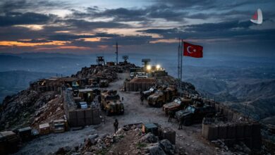 Turkish military outpost with armored vehicles and a flag situated on a rocky mountain peak