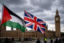 Palestinian and British flags waving in front of the Palace of Westminster in London