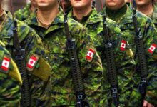 Soldiers of the Canadian Armed Forces, dressed in military uniforms and carrying weapons, moving through an outdoor environment