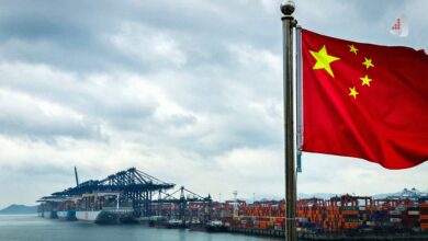 The Chinese flag in the background of an industrial complex and a construction project, symbolizing China’s industrial economy and its production challenges