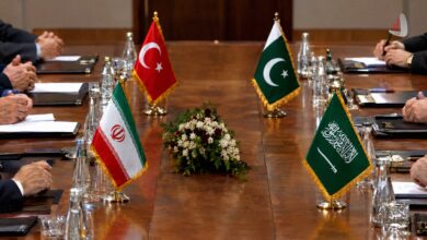 Table with flags of Iran, Turkey, Pakistan, and Saudi Arabia during a diplomatic meeting