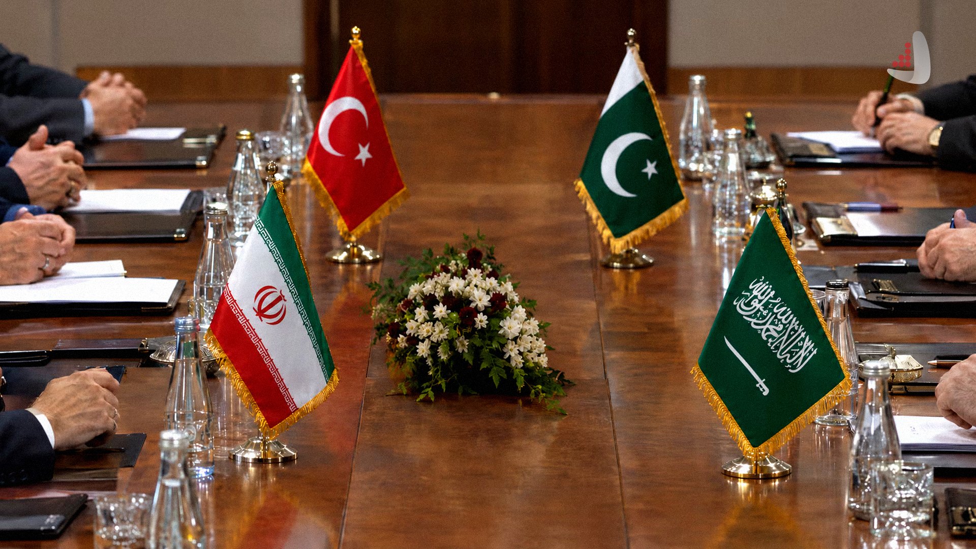 Table with flags of Iran, Turkey, Pakistan, and Saudi Arabia during a diplomatic meeting