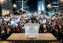 Clear ballot box on a table in front of a massive crowd of anti-government protesters in Tel Aviv