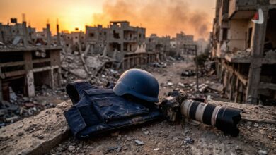 Dark press body armor vest, blue helmet, and professional camera on the edge of a destroyed building