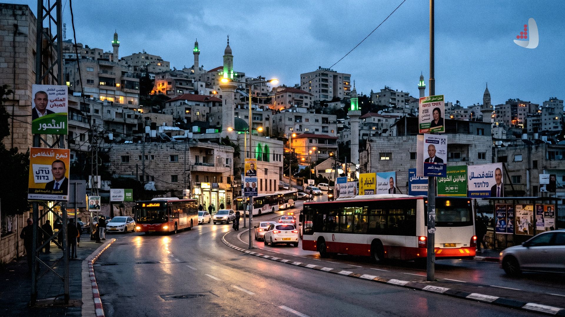 A city street at dusk with buses, election posters, and illuminated mosque minarets in the background