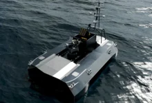 Graphic illustration of an armed military uncrewed surface vessel navigating ocean waves
