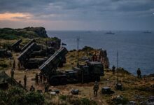 Japanese missile launchers deployed on a coastal cliff with warships in the ocean