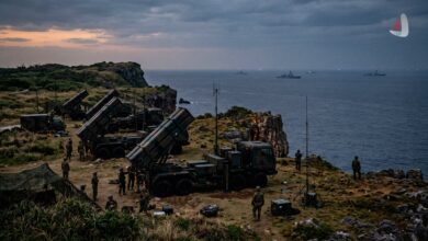 Japanese missile launchers deployed on a coastal cliff with warships in the ocean